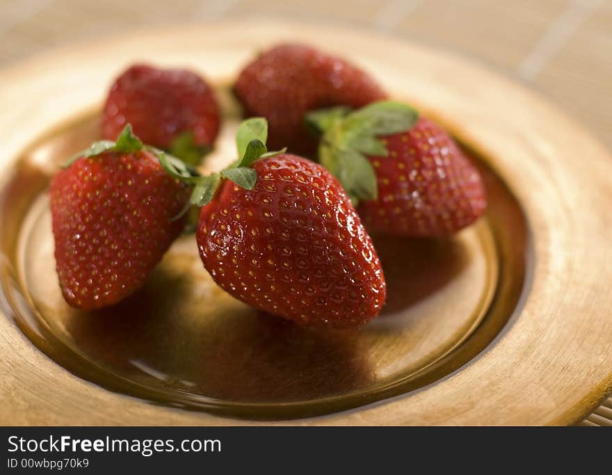 Strawberry fruit on golden plte close up shoot