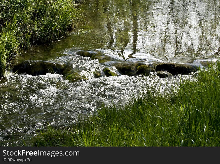 Shallow creek. Sun glare in the water