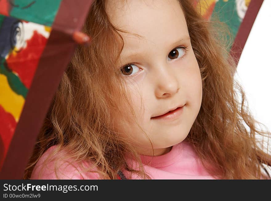 The little girl sits under an umbrella. The little girl sits under an umbrella