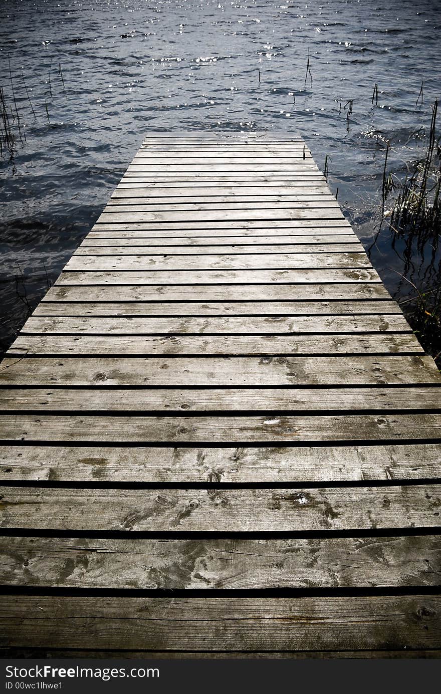 Weathered wooden pier - intentional vignetting and desaturation. Weathered wooden pier - intentional vignetting and desaturation.