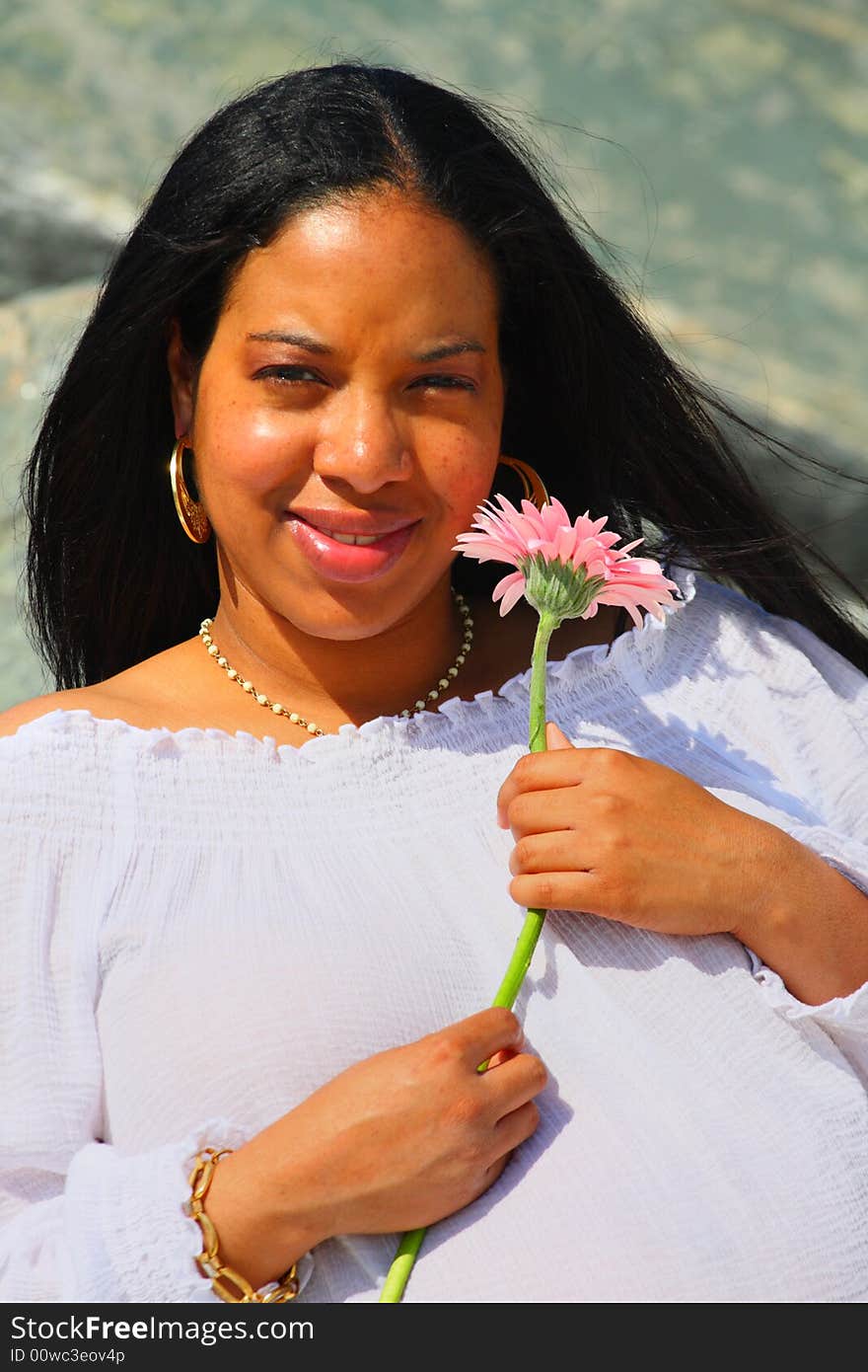 Young Black woman holding a pink flower