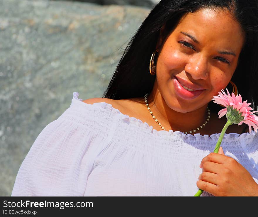 Black woman holding a pink daisy. Black woman holding a pink daisy