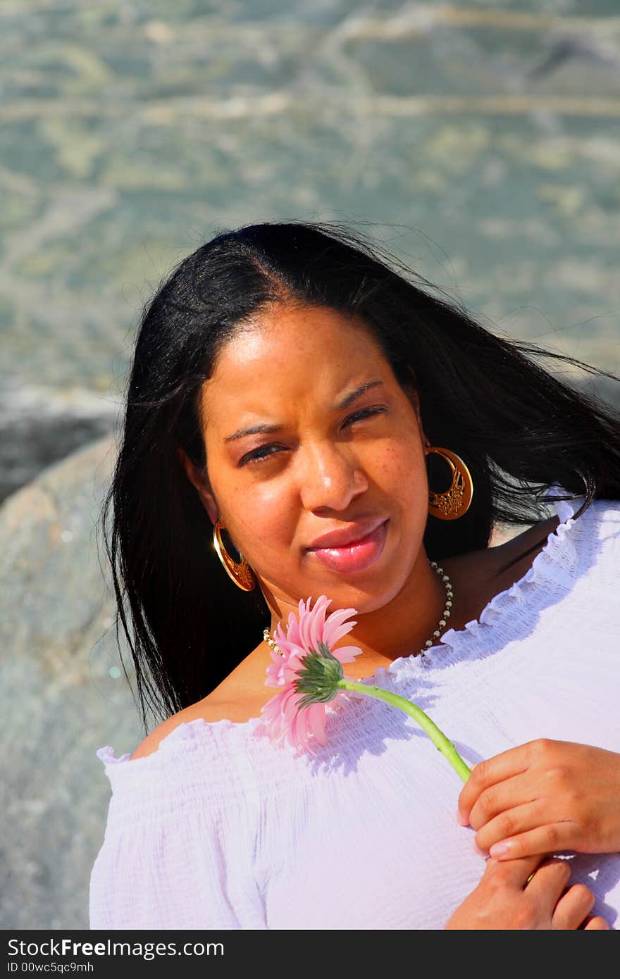 Black woman holding a pink daisy. Black woman holding a pink daisy