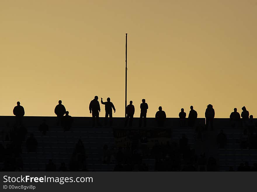 Soccer fans silhouettes in sunset