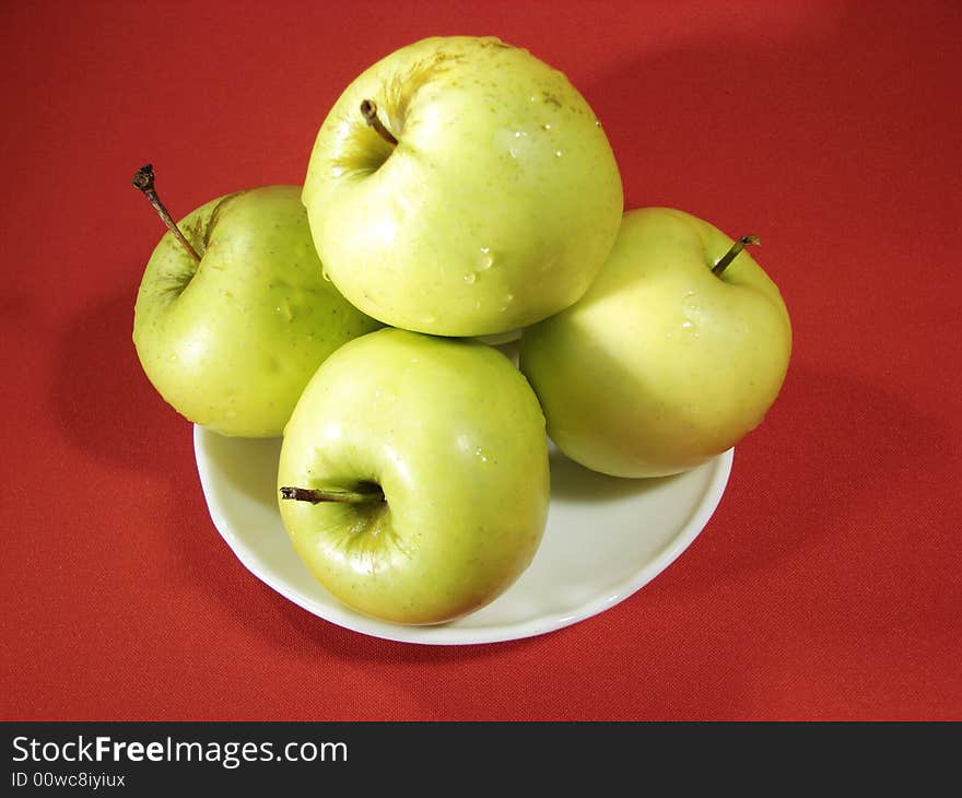 Several green apples on red