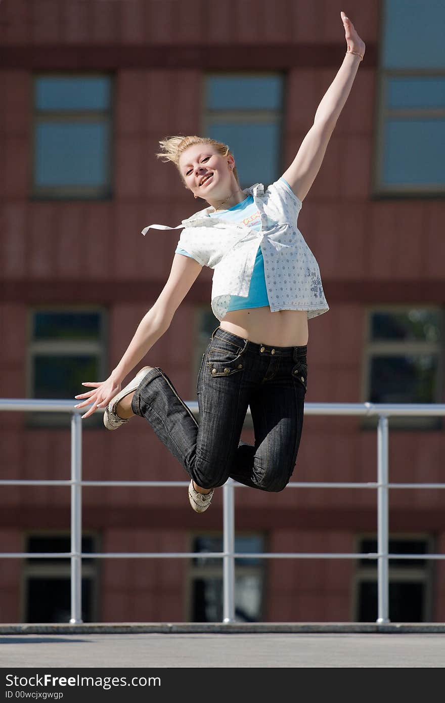 Beautiful girl jumps on a background of a building