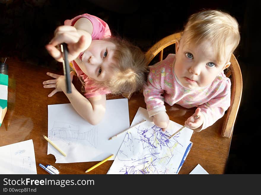 A two girls with pencils drawing a picture. A two girls with pencils drawing a picture