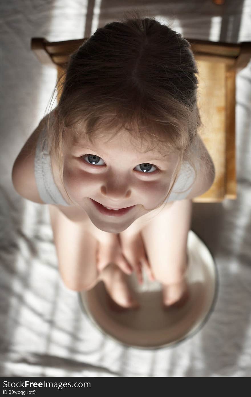 A nice girl washing her feet in a white wash-basin. A nice girl washing her feet in a white wash-basin