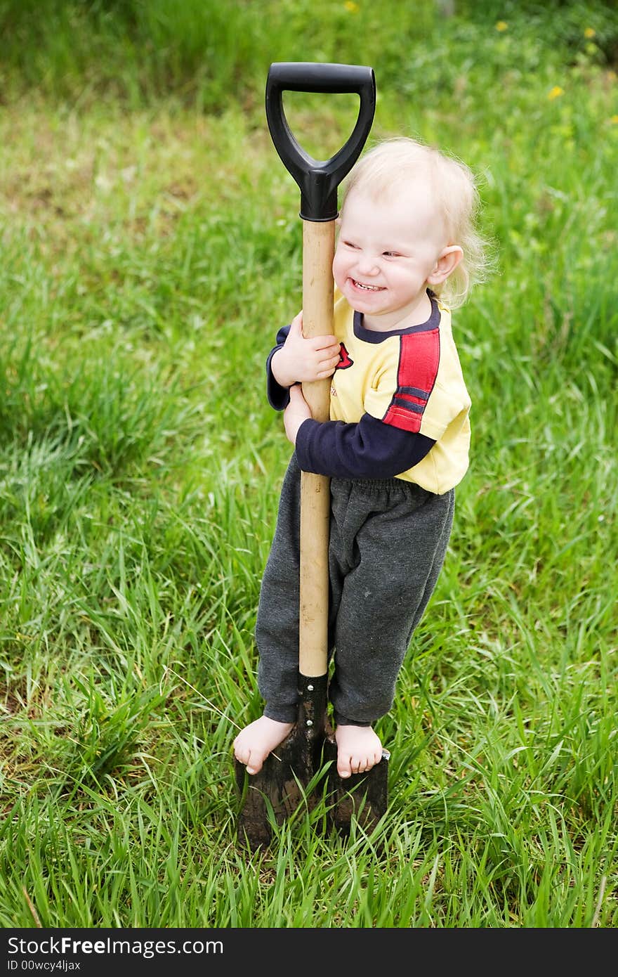 Small girl on the shovel in the garden. Small girl on the shovel in the garden