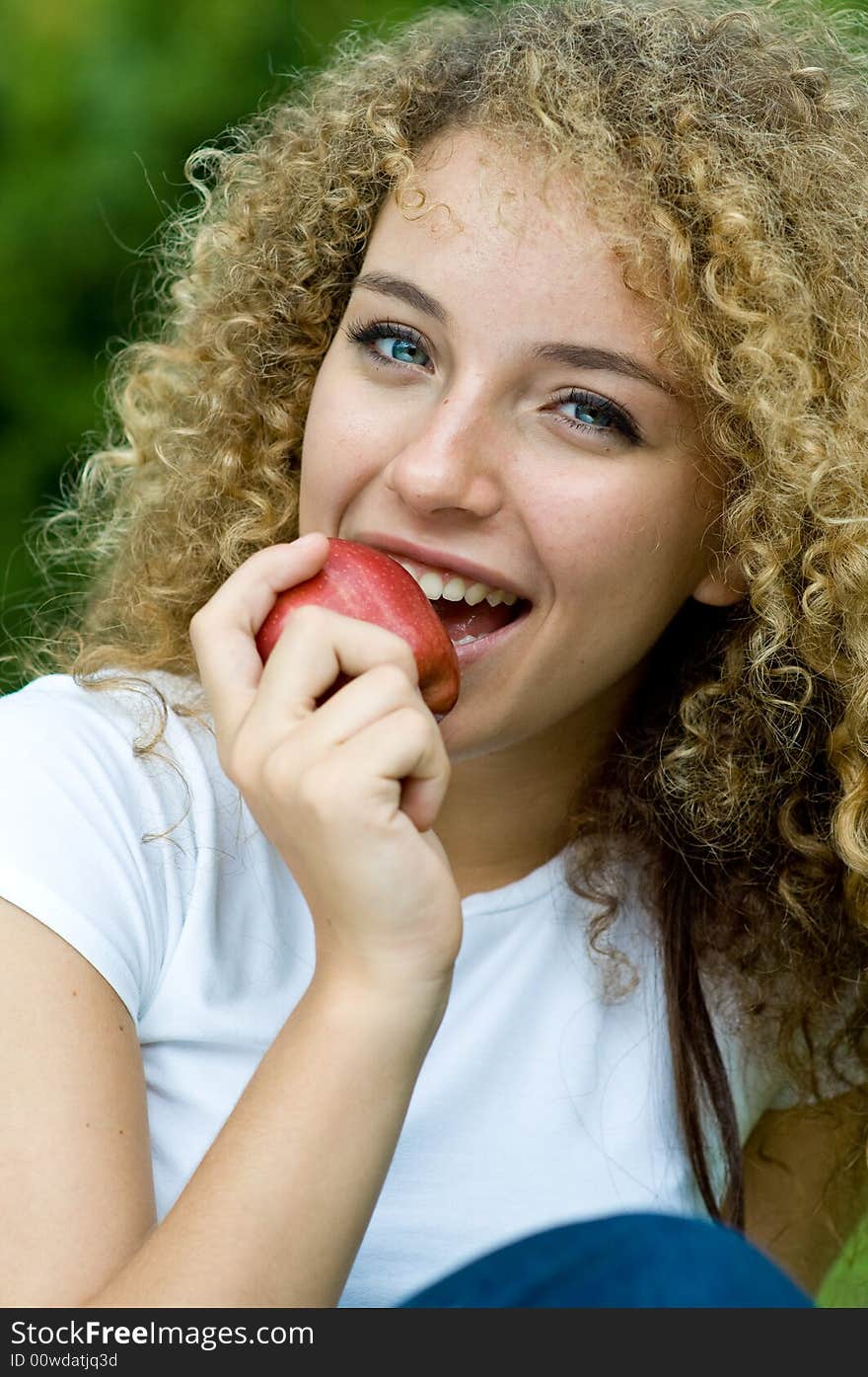 A young attractive woman holding an apple