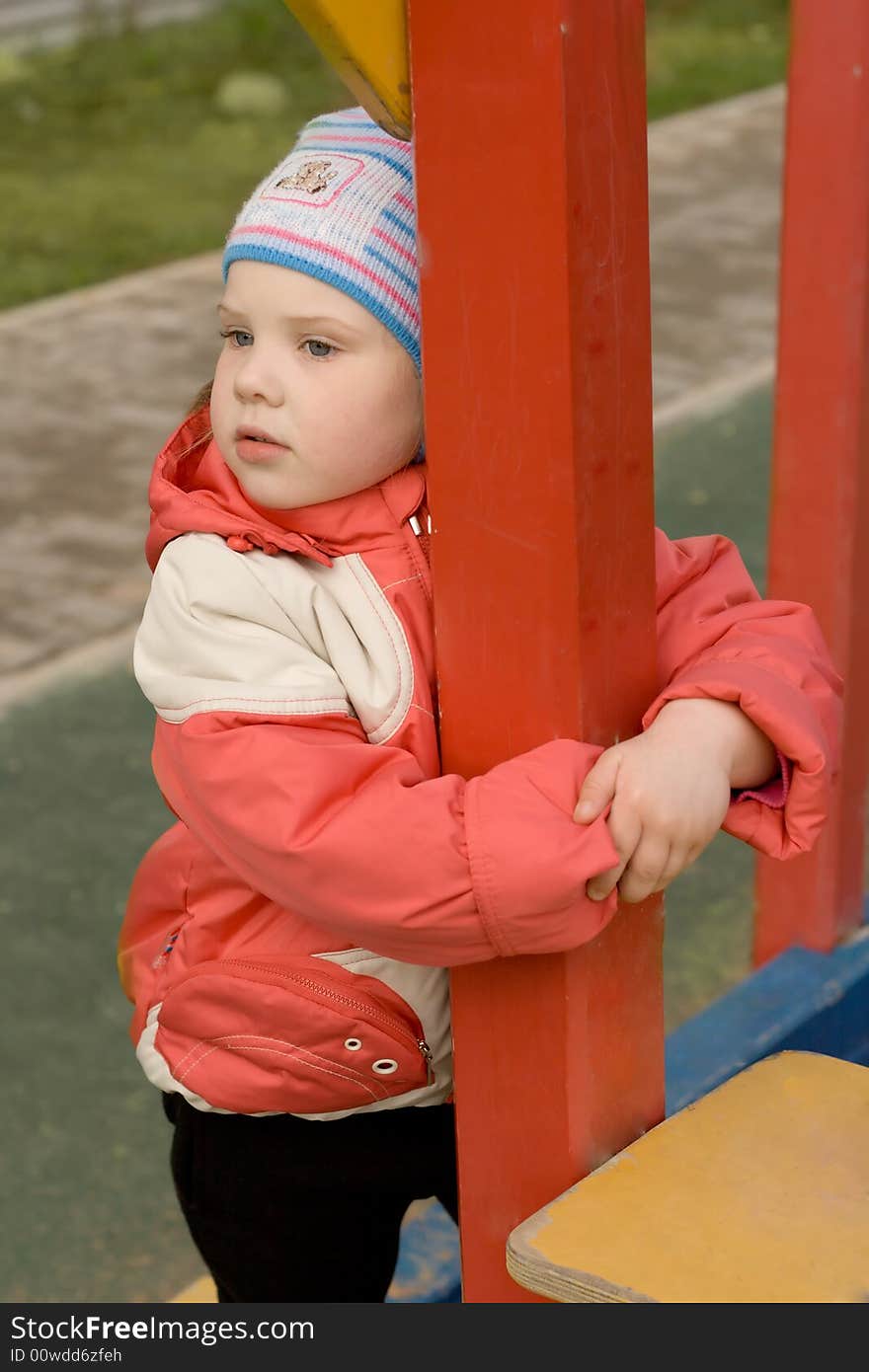 A sad young girl standing near column. A sad young girl standing near column