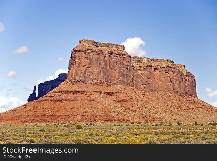 Monolith Towering Red Sandstone in Monument valley is unique and most well known for Old West site setting for Movies. The Monument Valley was created as material eroded from the ancestral Rocky Mountains, and was deposited and cemented into sandstone. The formations you see in the valley were left over after the forces of erosion worked their magic on the sandstone. Monolith Towering Red Sandstone in Monument valley is unique and most well known for Old West site setting for Movies. The Monument Valley was created as material eroded from the ancestral Rocky Mountains, and was deposited and cemented into sandstone. The formations you see in the valley were left over after the forces of erosion worked their magic on the sandstone.