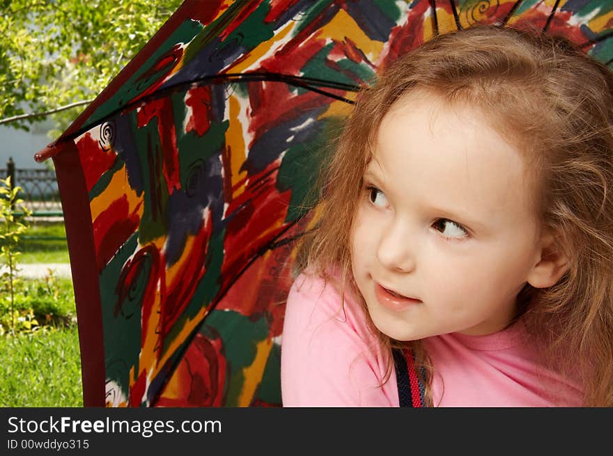 Little girl sits under an umbrella. Little girl sits under an umbrella