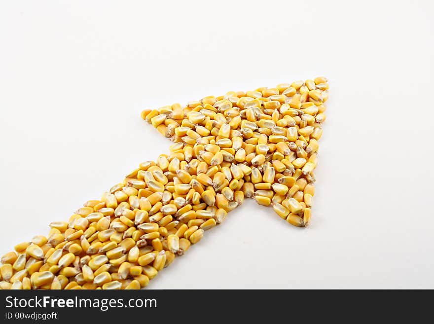 A pile of corn kernels arranged into an up arrow to reflect the high price of corn. A pile of corn kernels arranged into an up arrow to reflect the high price of corn