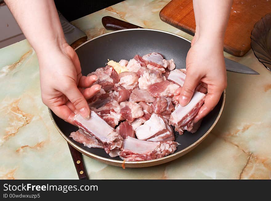 Placing meat pieces in frying pan. Stage 1.