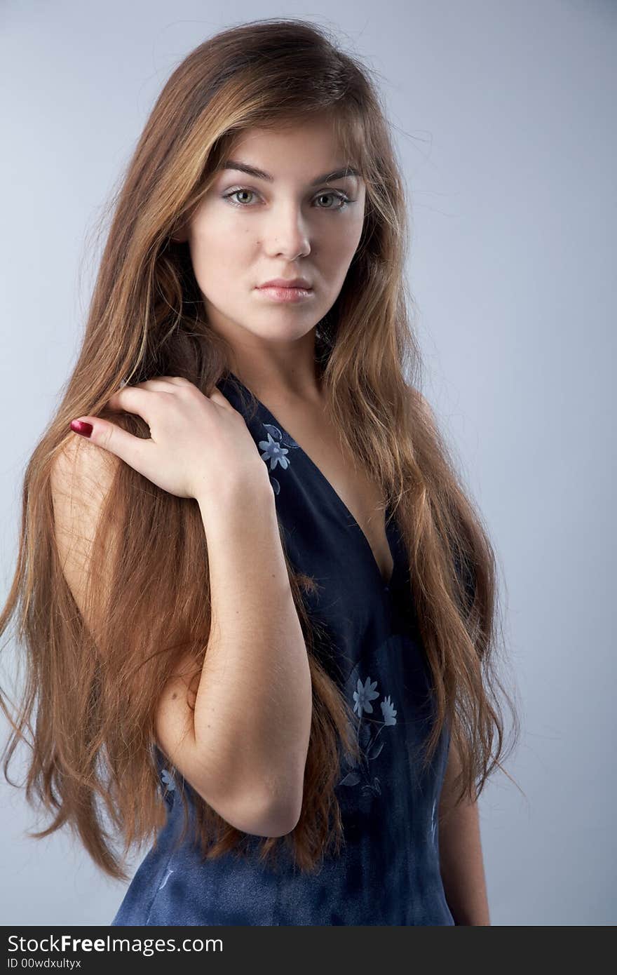 Beautiful girl with long hair looking to camera on grey background