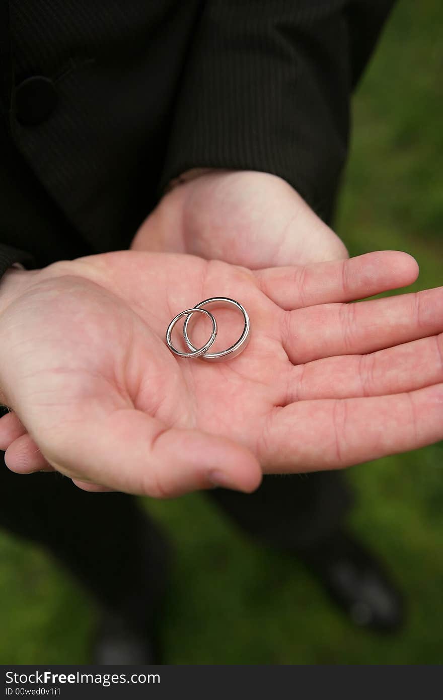 Hands holding wedding rings DOF focus on bands