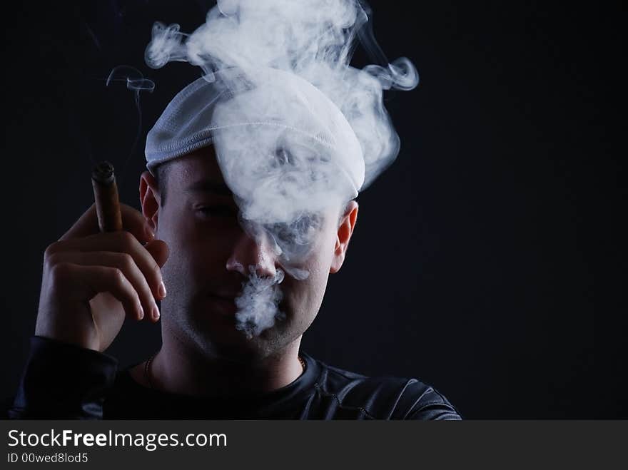 Man with cigare at black background