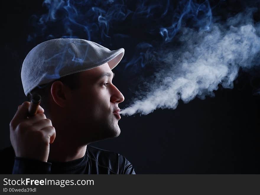 Man with cigare at black background