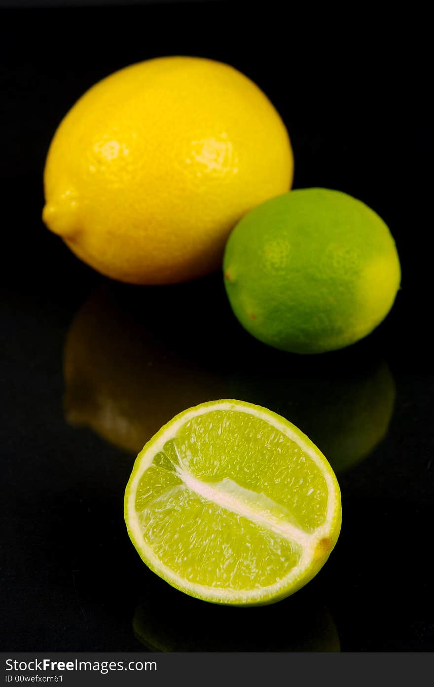 Lemon and lime fruit isolated against a black background. Lemon and lime fruit isolated against a black background