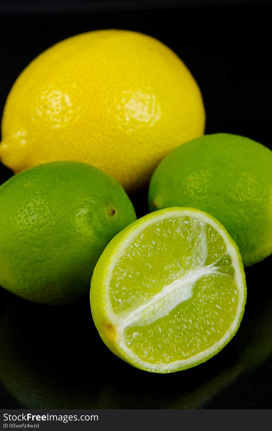 Lemon and lime fruit isolated against a black background. Lemon and lime fruit isolated against a black background