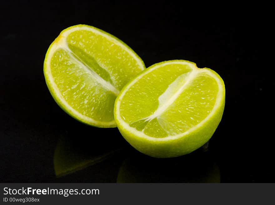 Lemon and lime fruit isolated against a black background. Lemon and lime fruit isolated against a black background