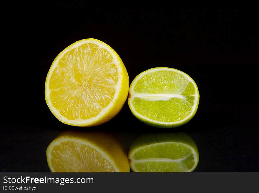 Lemon and lime fruit isolated against a black background. Lemon and lime fruit isolated against a black background