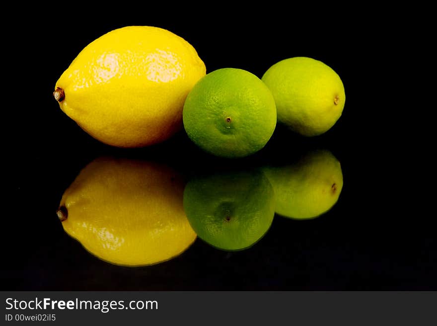 Lemon and lime fruit isolated against a black background. Lemon and lime fruit isolated against a black background