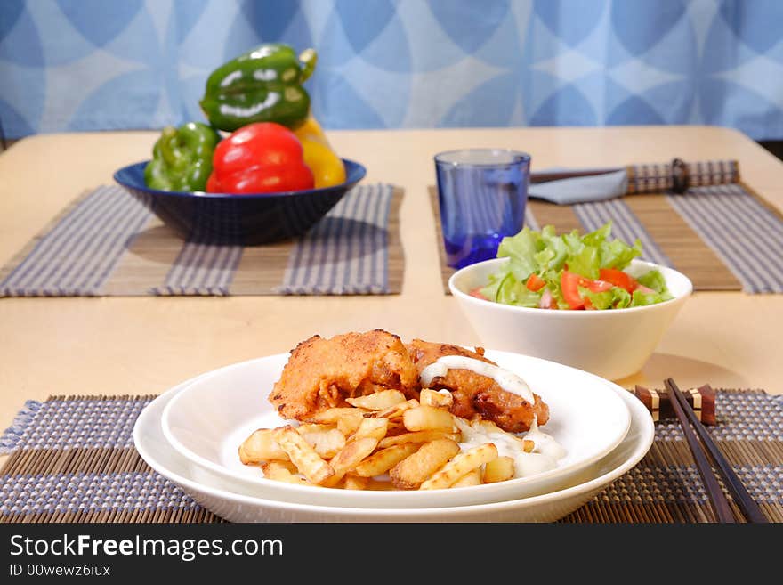 French fries and chicken legs on the plate with garlic sauce