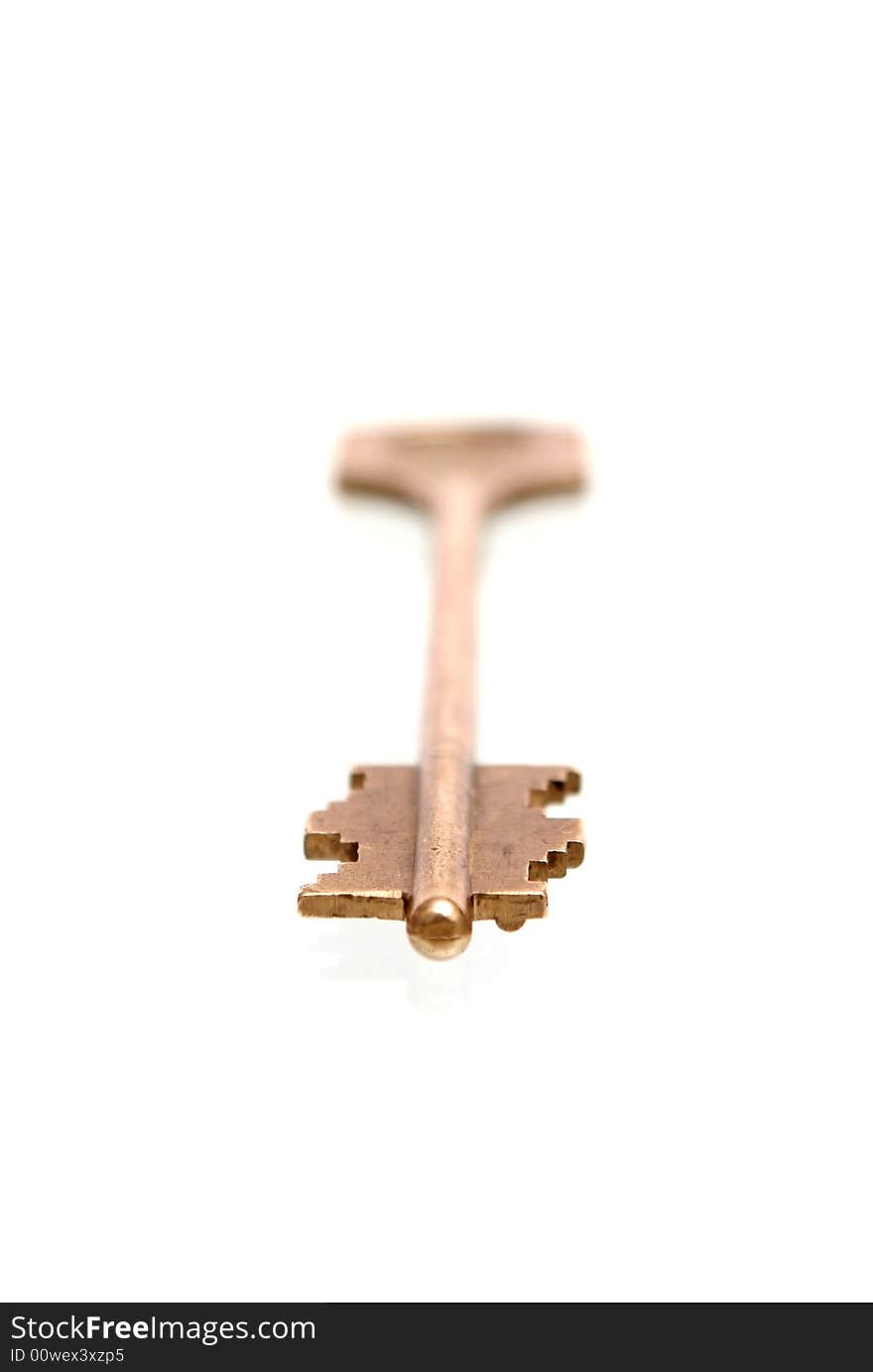 The gold key lays on a white background