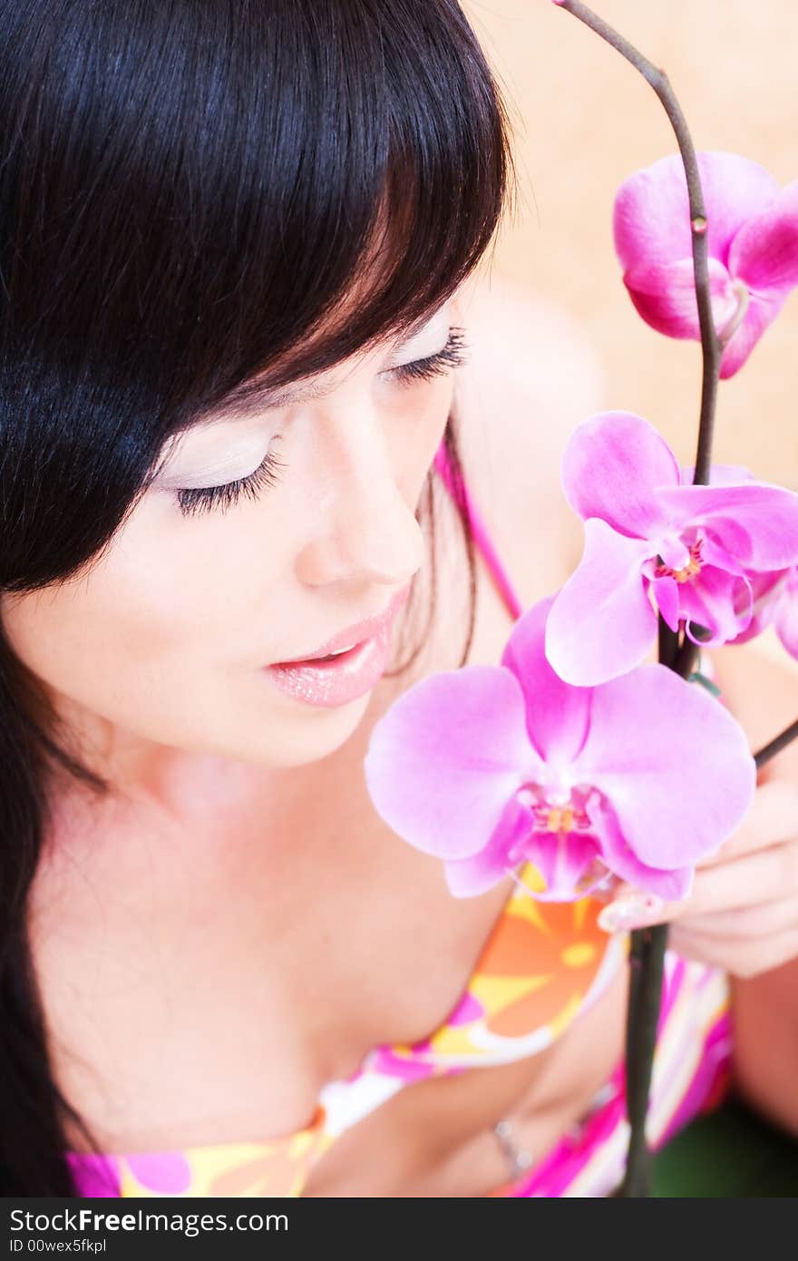 Beautiful asian girl with orchid. Low DOF, focus on eyes