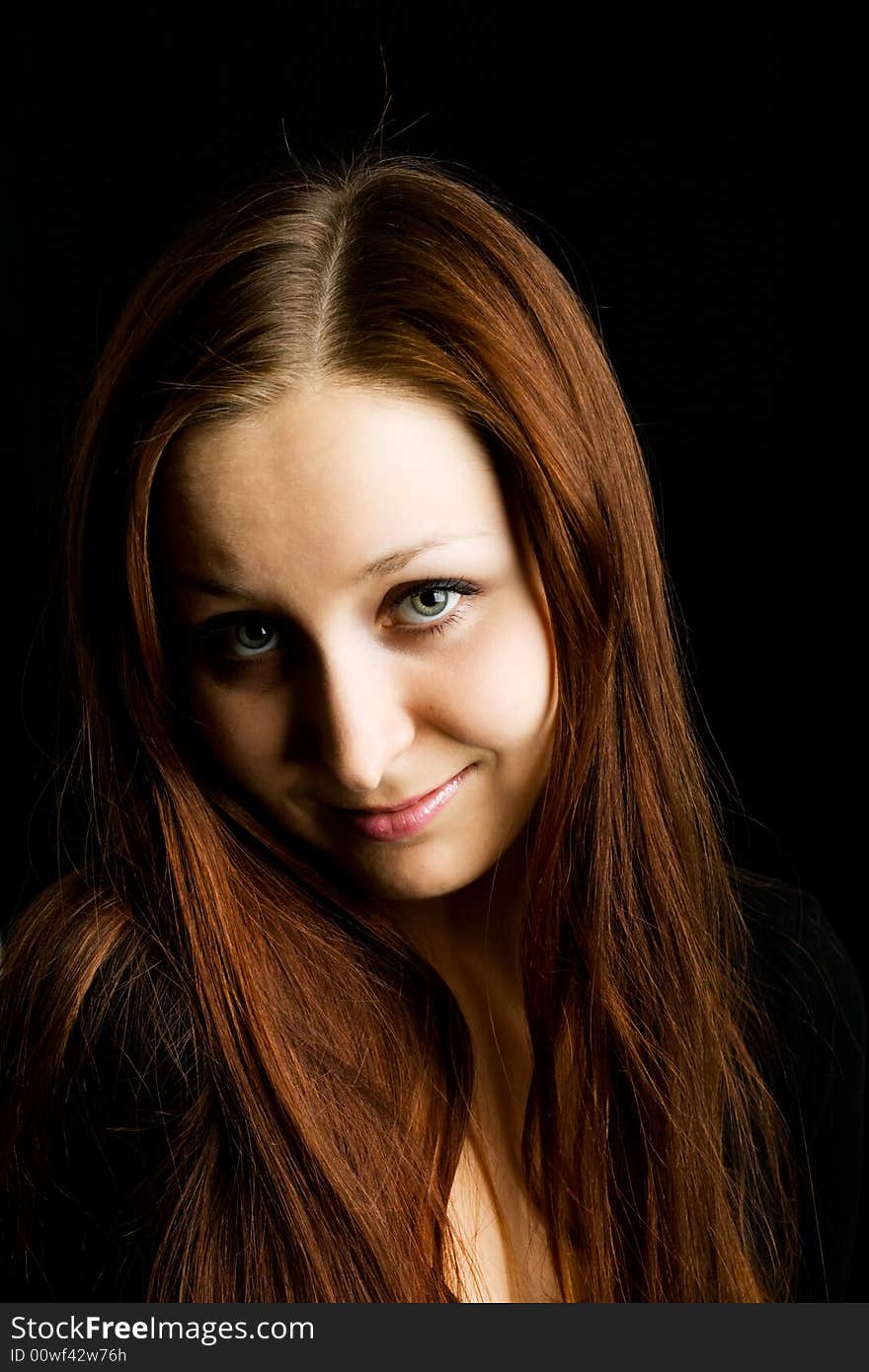 Close-up of woman`s face with long hairs against a black background