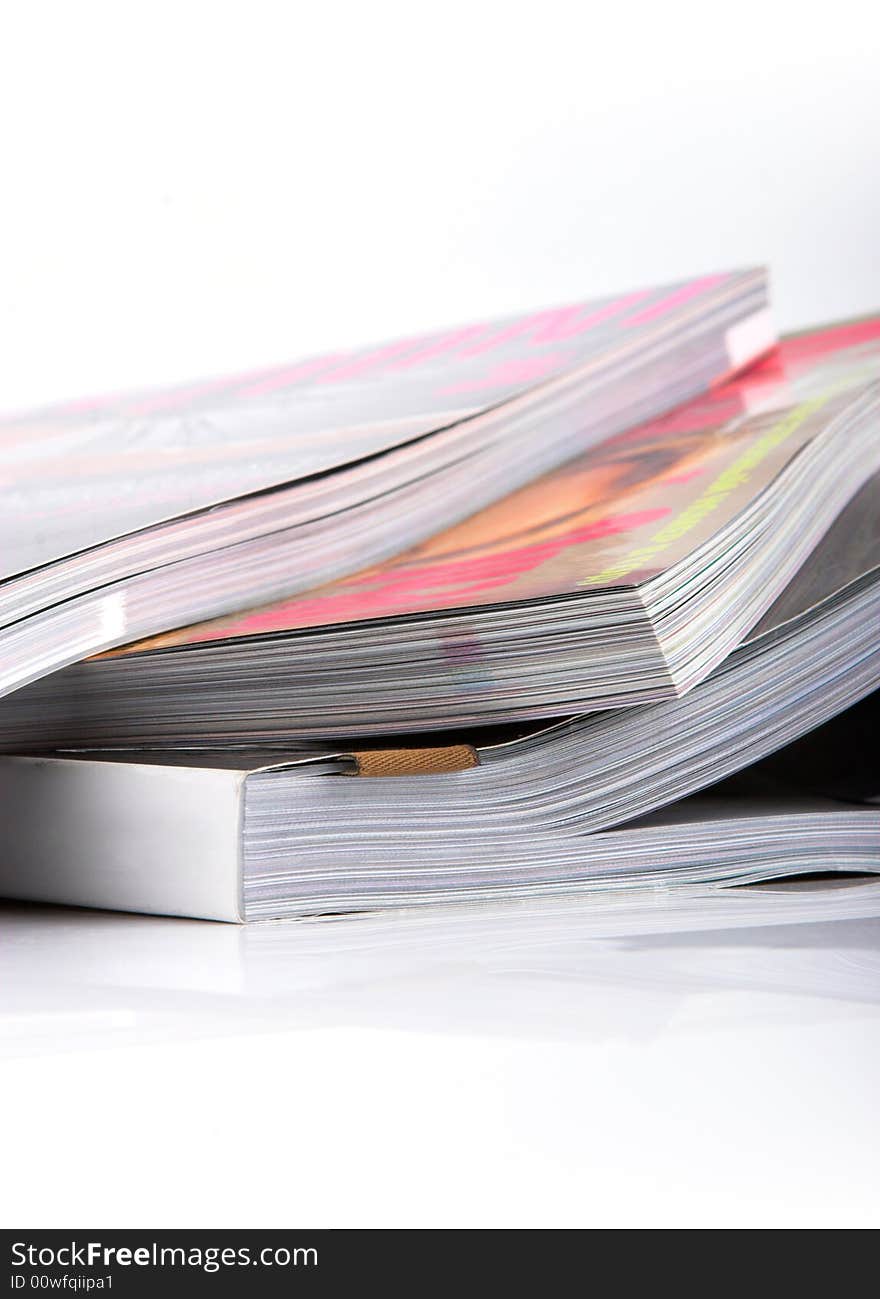 Stack of glossy magazines on a white background.