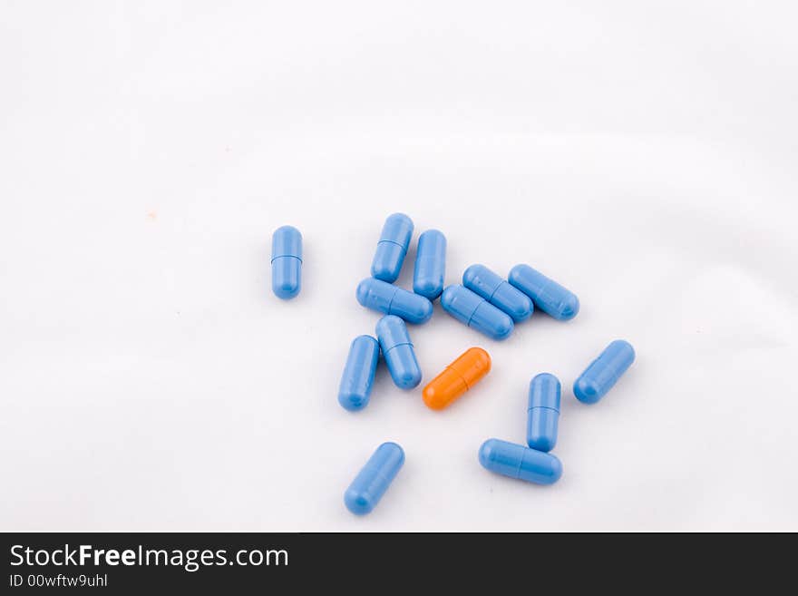 Set of blue and orange pills, white background