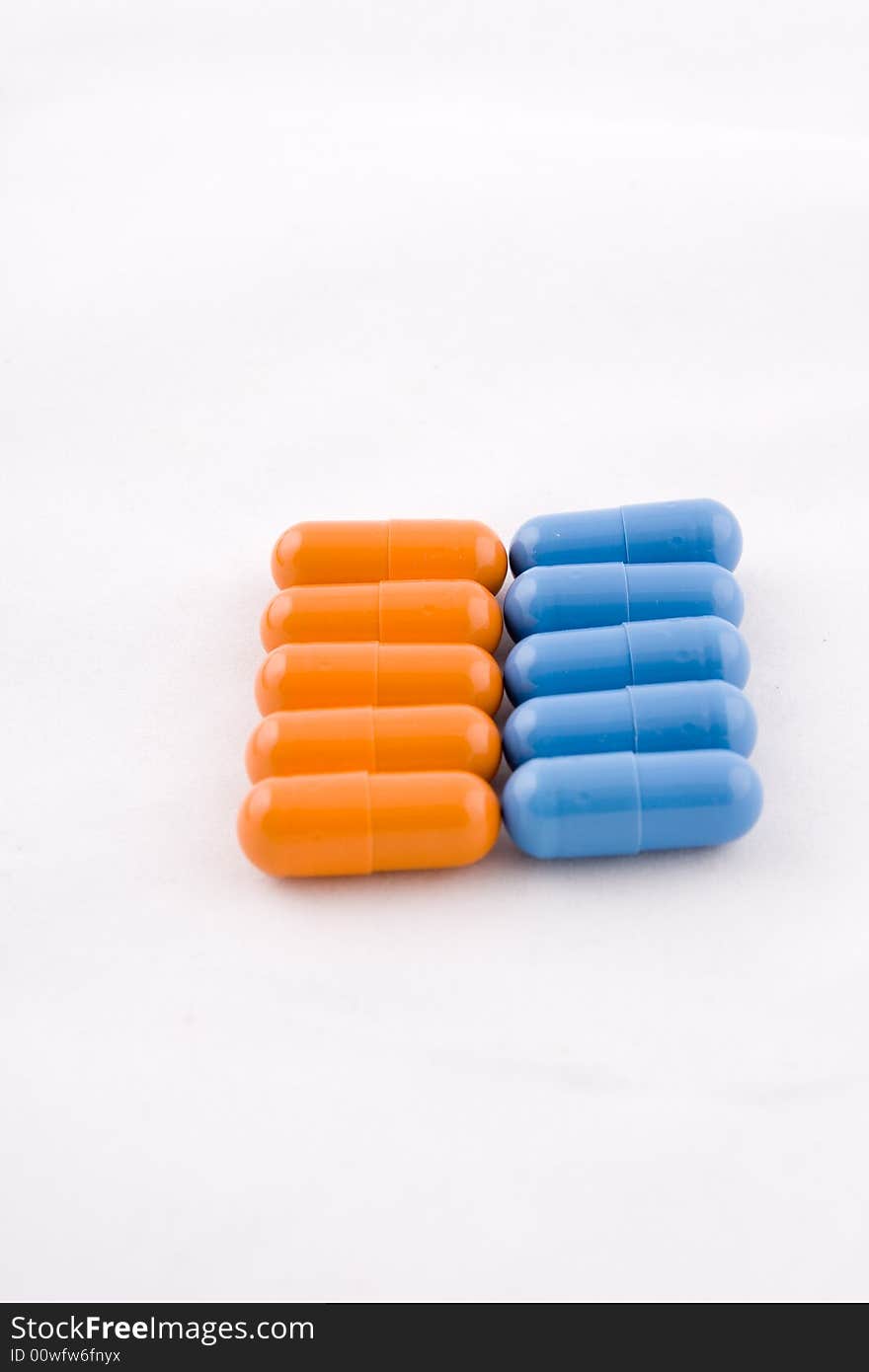 Set of blue and orange pills, white background