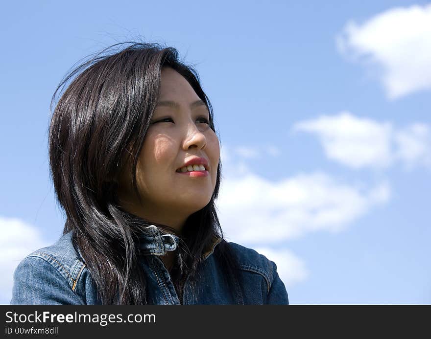 Attractive young woman portrait over sky background with room for text. Attractive young woman portrait over sky background with room for text