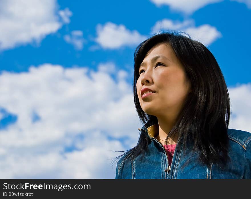 Attractive young woman portrait over sky background with room for text. Attractive young woman portrait over sky background with room for text