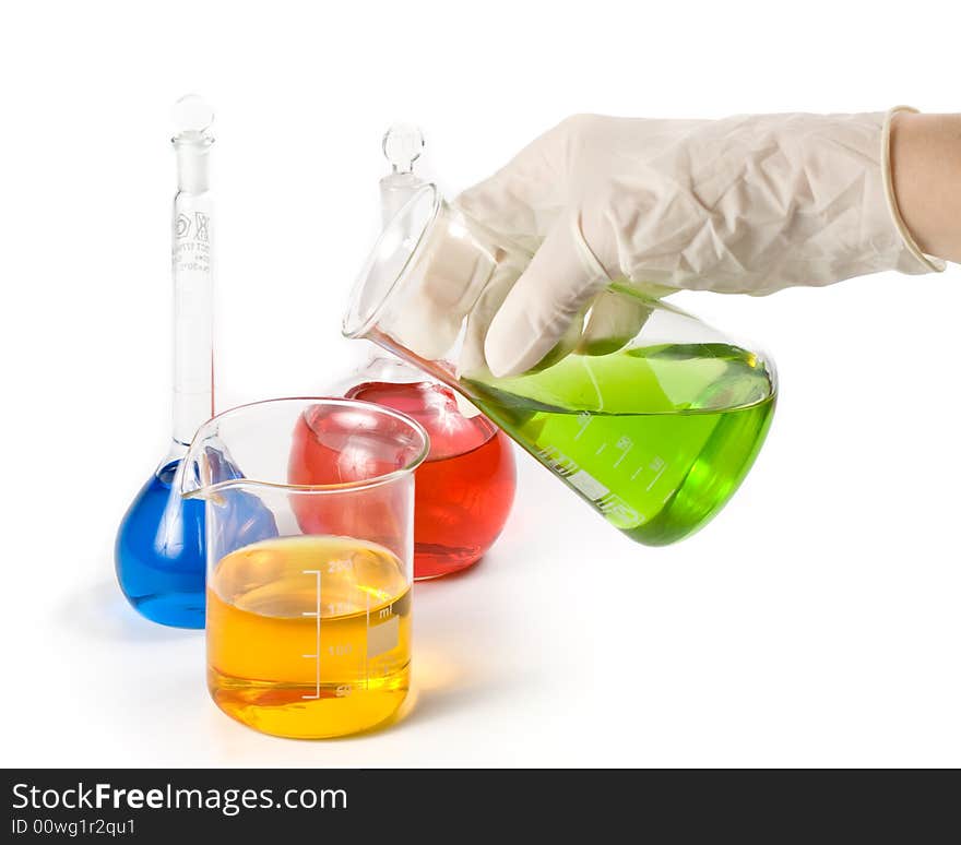 Various colorful flasks and hand in glove over white background