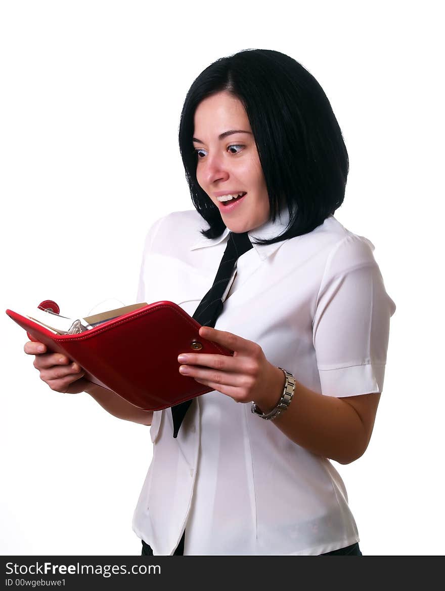 A portrait about a young attractive businesswoman with black hair who is holding a red calendar, she is happy because she found some free time in the agenda. She is wearing a white shirt and a black tie. A portrait about a young attractive businesswoman with black hair who is holding a red calendar, she is happy because she found some free time in the agenda. She is wearing a white shirt and a black tie.