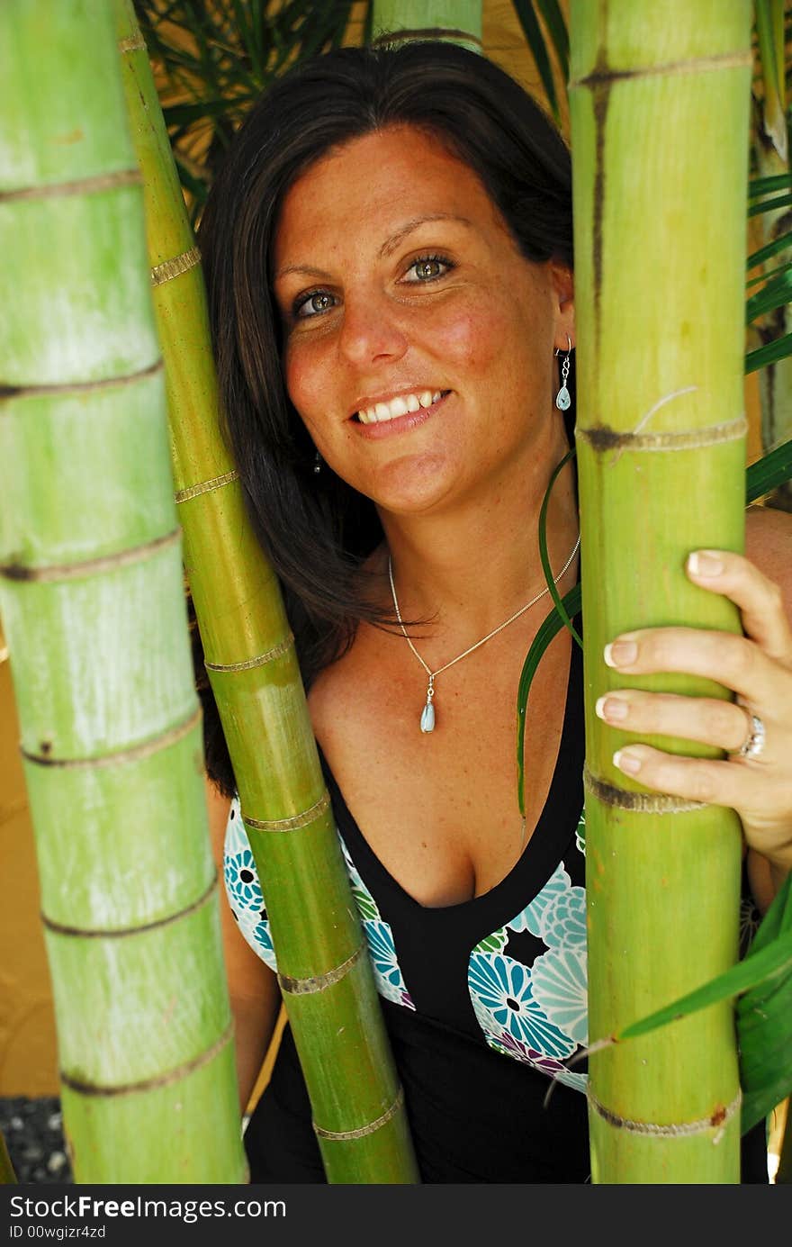 Beautiful woman posing behind bamboo shoots in a tropical location. Beautiful woman posing behind bamboo shoots in a tropical location