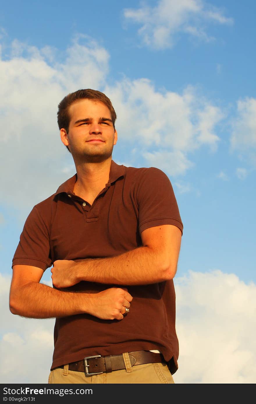 Caucasian man flexing his muscles with sky background. Caucasian man flexing his muscles with sky background.