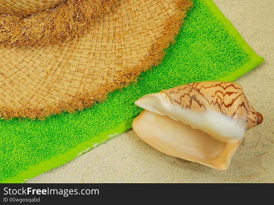 Seashell, straw hat on sand