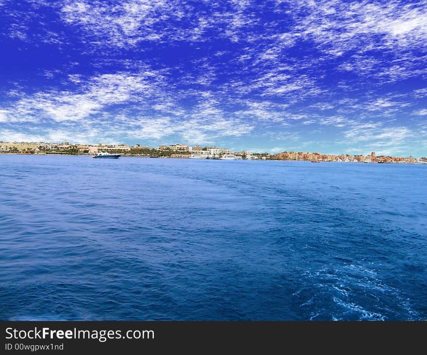 Blue sky and blue sea.View to town on shore. Blue sky and blue sea.View to town on shore