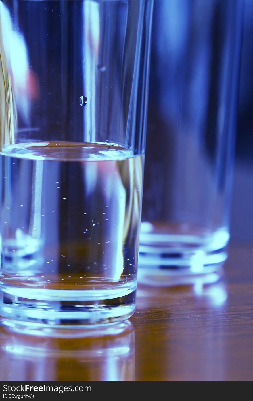 Blue glass of water with reflection