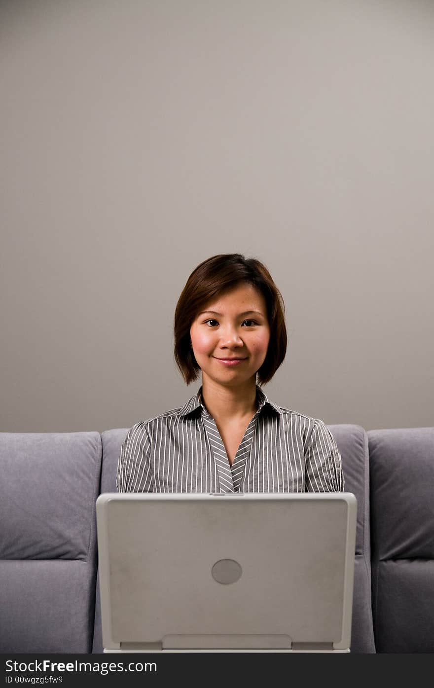 Asian lady in business attire, using a computer