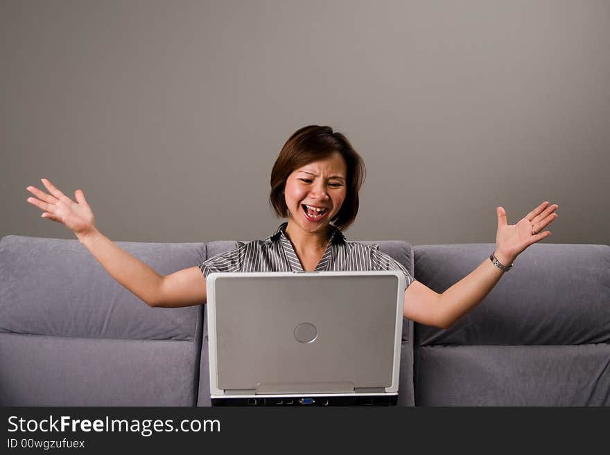 Asian lady in business attire, frustrated working on a notebook computer