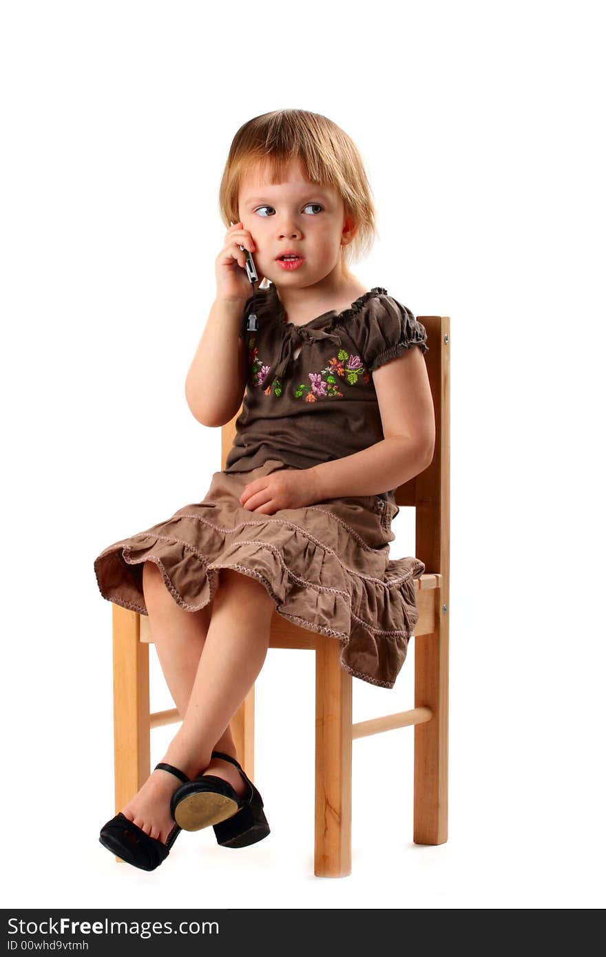 Little pretty girl in big shoes sitting on chair and talking by mobile phone with her friends. Little pretty girl in big shoes sitting on chair and talking by mobile phone with her friends.
