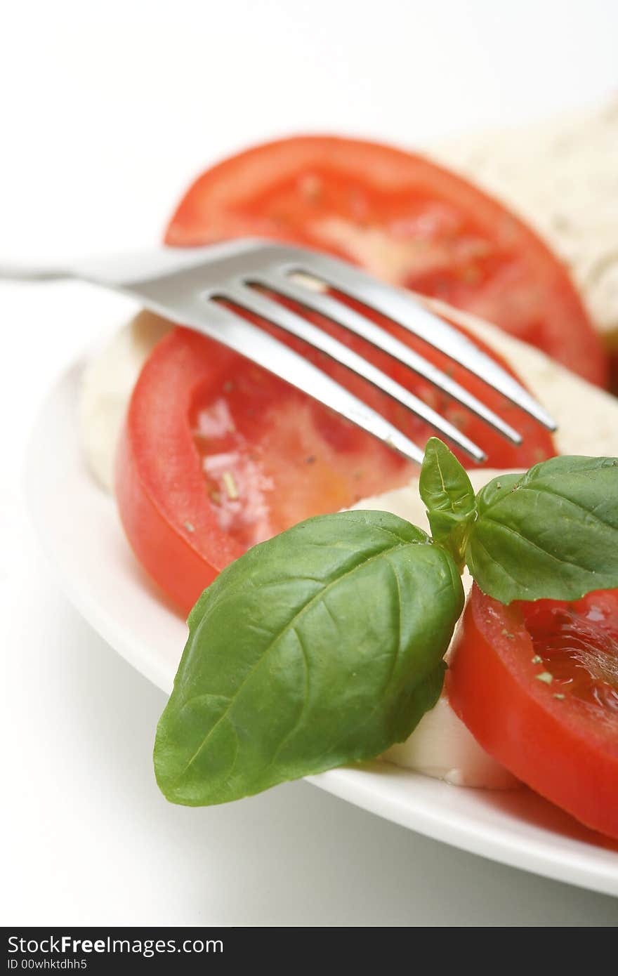 Close up of mozzarella tricolore salad with tomatoes and basil with drizzling of olive oil. Close up of mozzarella tricolore salad with tomatoes and basil with drizzling of olive oil.