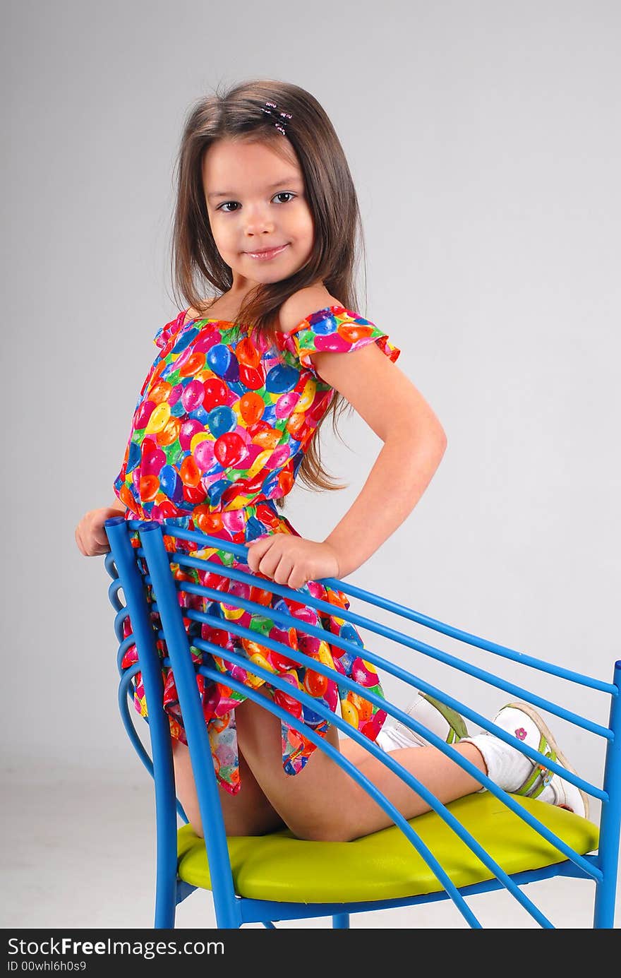 Little Girl Sitting On A Chair