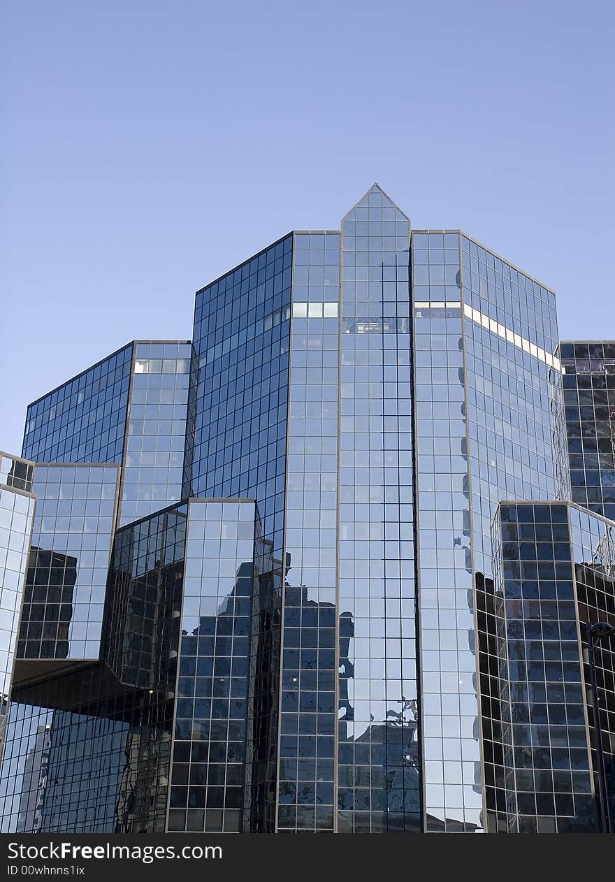 A modern blue glass financial center reflecting surroundings. A modern blue glass financial center reflecting surroundings